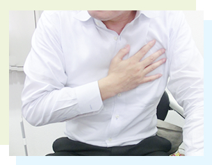 心臓を押さえる男性